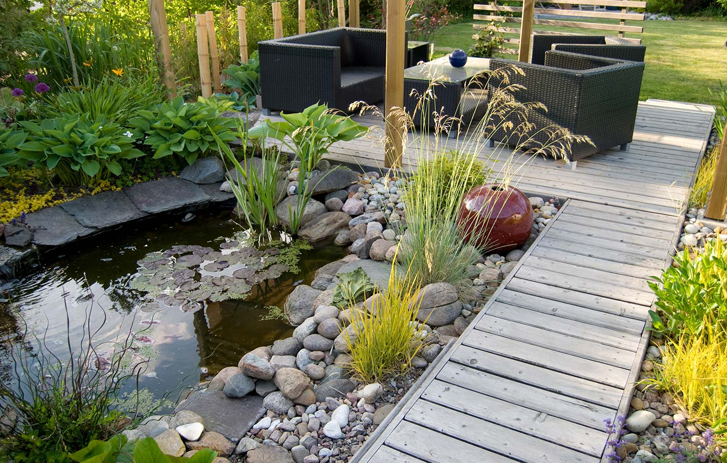 Teich mit Gartenweg und Terrasse aus Holzdielen